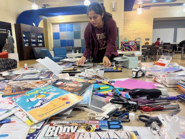 A student engages in zine-making at Wright State University's "Crafternoons in the Library" creative event.